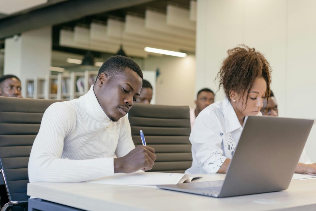 Diverse group of young professionals in a collaborative business meeting setting, actively participating.